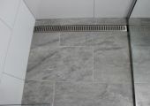 Tiled shower base with grate